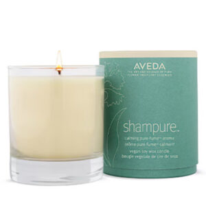 A Shampure Candle in a glass jar next to its cylindrical green paper packaging. - SAAB Salon Spa | Ottawa On, Canada