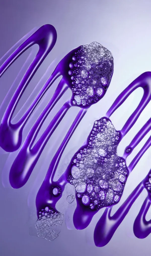 Close-up of NEW botanical repair™ purple toning shampoo with streaks of purple liquid and clusters of transparent bubbles on a smooth surface, set against a gradient light background. - SAAB Salon Spa | Ottawa On, Canada