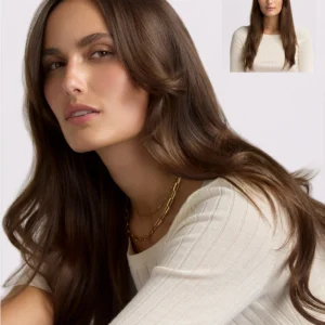 A woman with long, wavy brown hair styled using the T3 Aire360 wears a cream ribbed top and gold chain necklace; an inset shows her facing forward. - SAAB Salon Spa | Ottawa On, Canada