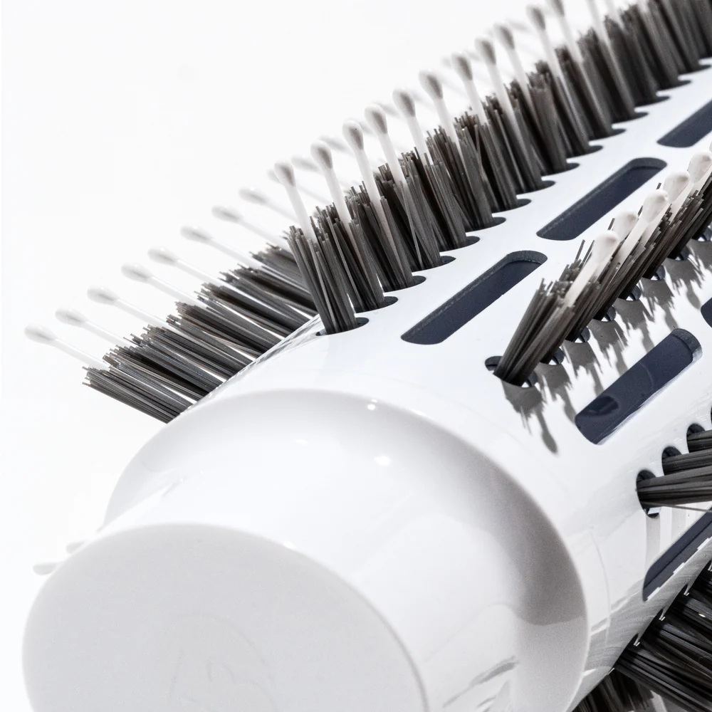 A close-up of the T3 Airebrush (Copy), a white cylindrical round hairbrush with black bristles, set against a plain white background. - SAAB Salon Spa | Ottawa On, Canada