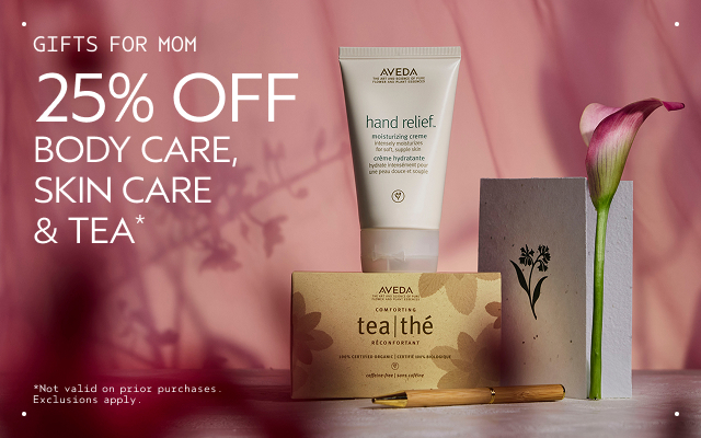 Promotional image showing Aveda products, a pink flower, and a note card with text: 