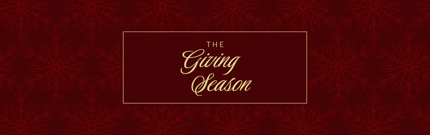 Text reading “The Giving Season” inside a gold-bordered rectangle, set against a dark red background with a repeating snowflake pattern. - SAAB Salon Spa | Ottawa On, Canada