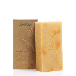 Rectangular Beautifying Bath Bar with mottled texture next to its upright cardboard packaging. - SAAB Salon Spa | Ottawa On, Canada