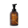 Amber plastic pump bottle of Beautifying Foaming Hand Wash with a black dispenser top and floral graphic. - SAAB Salon Spa | Ottawa On, Canada